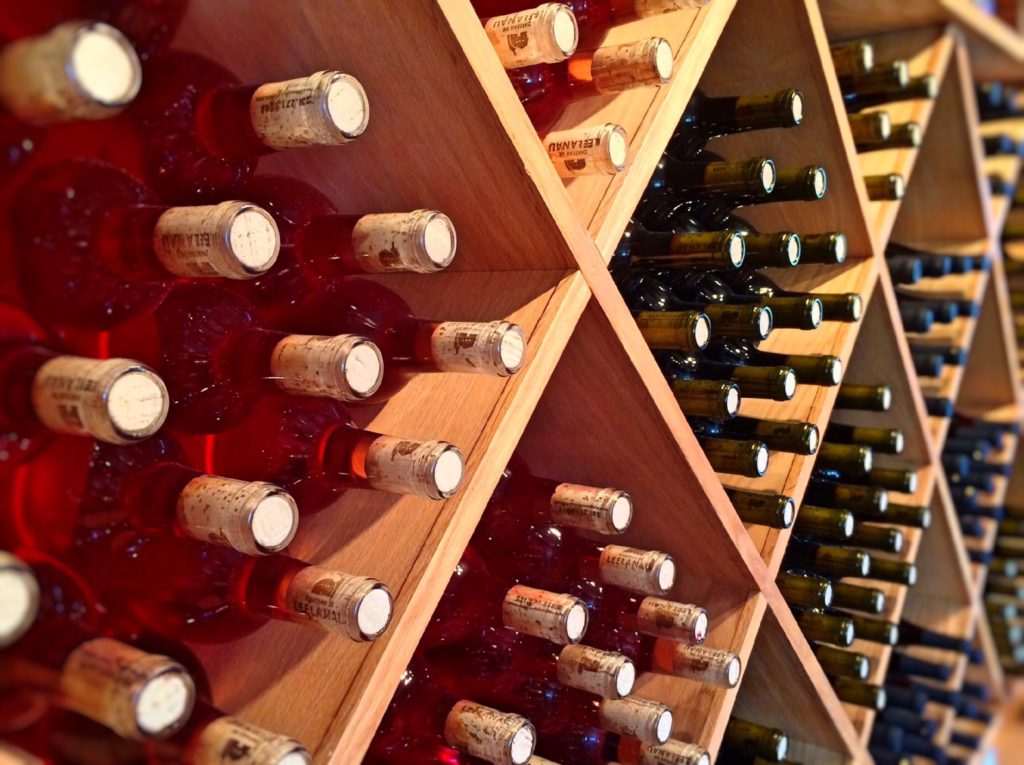 Wine bottles laying on their sides stacked in diagonal crates in a wine commercial.